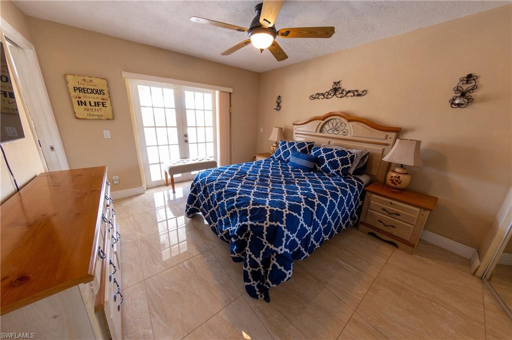 Bedroom featuring french doors, a ceiling fan, and a textured ceiling