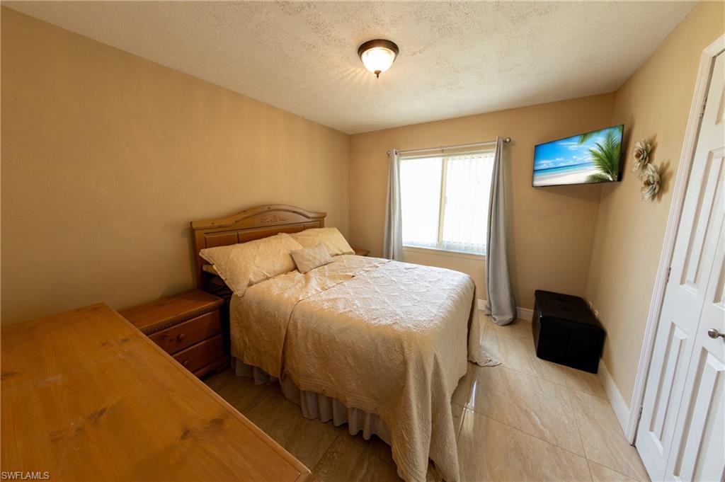 Bedroom with a textured ceiling and baseboards