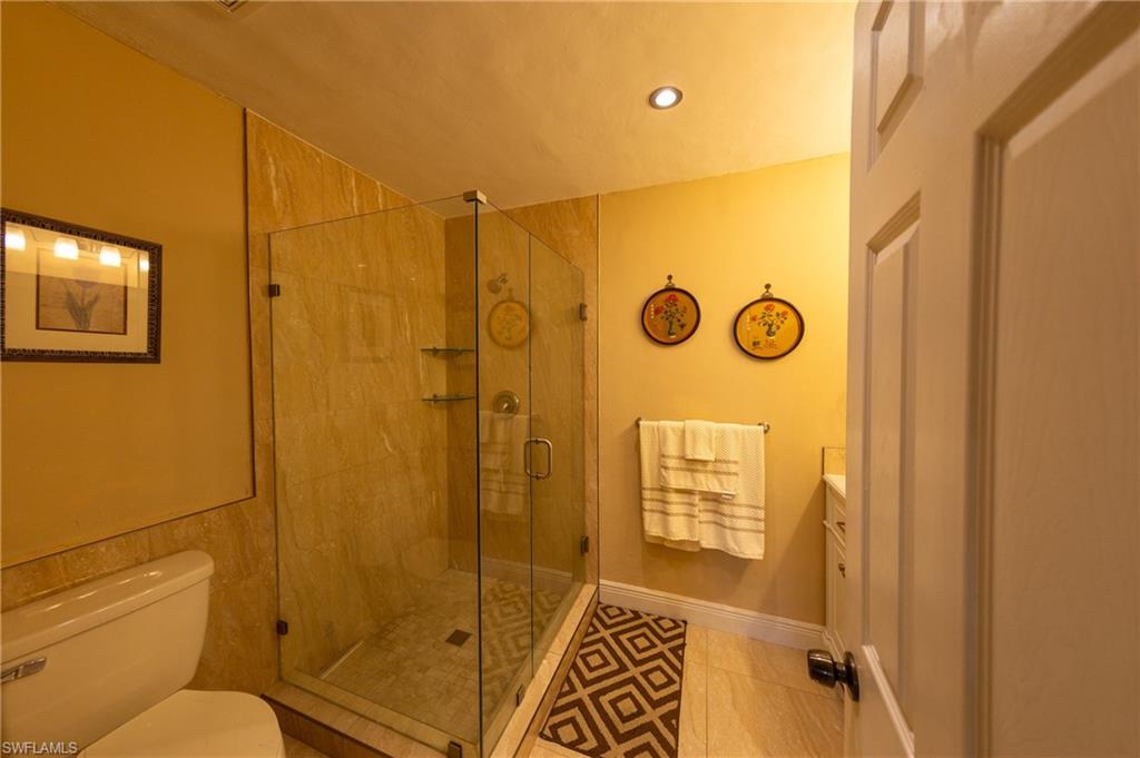 Full bathroom featuring vanity, a stall shower, light tile patterned flooring, and recessed lighting