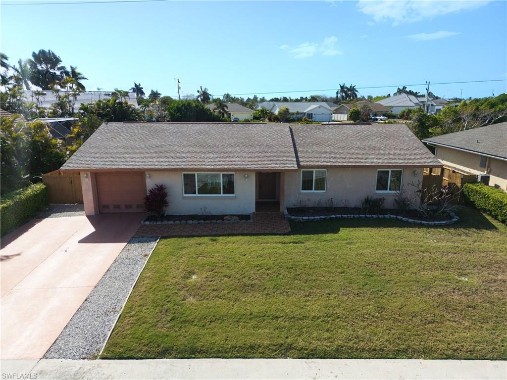Ranch-style home featuring concrete driveway, stucco siding, a shingled roof, and an attached garage
