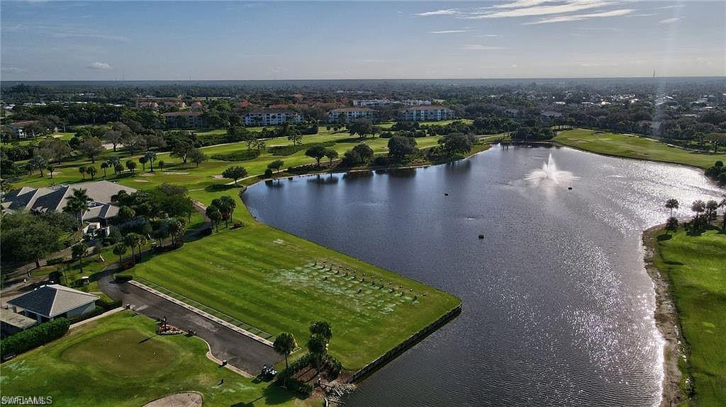 Expansive golf course landscape featuring a large water body with a fountain