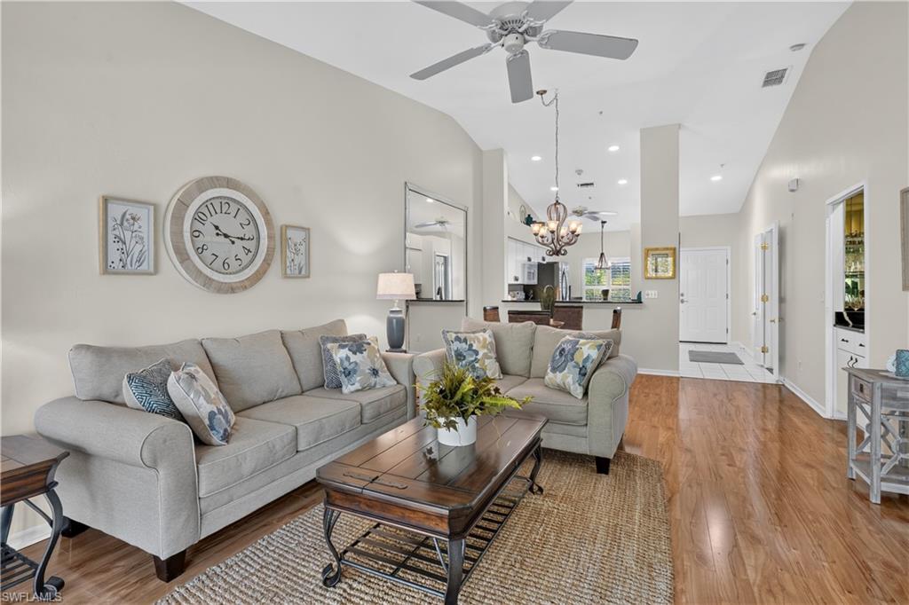 Vaulted ceilings, wood-finish flooring, ceiling fan, recessed lighting, and a built-in wet bar
