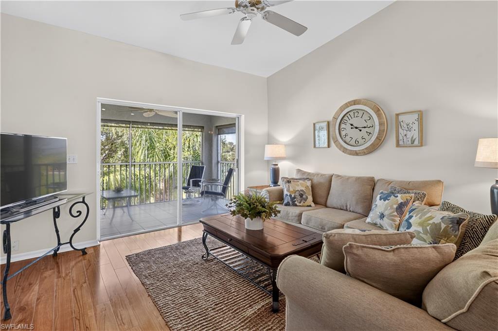 Vaulted ceiling, ceiling fan, wood-finish flooring, sliding glass doors, and a screened balcony
