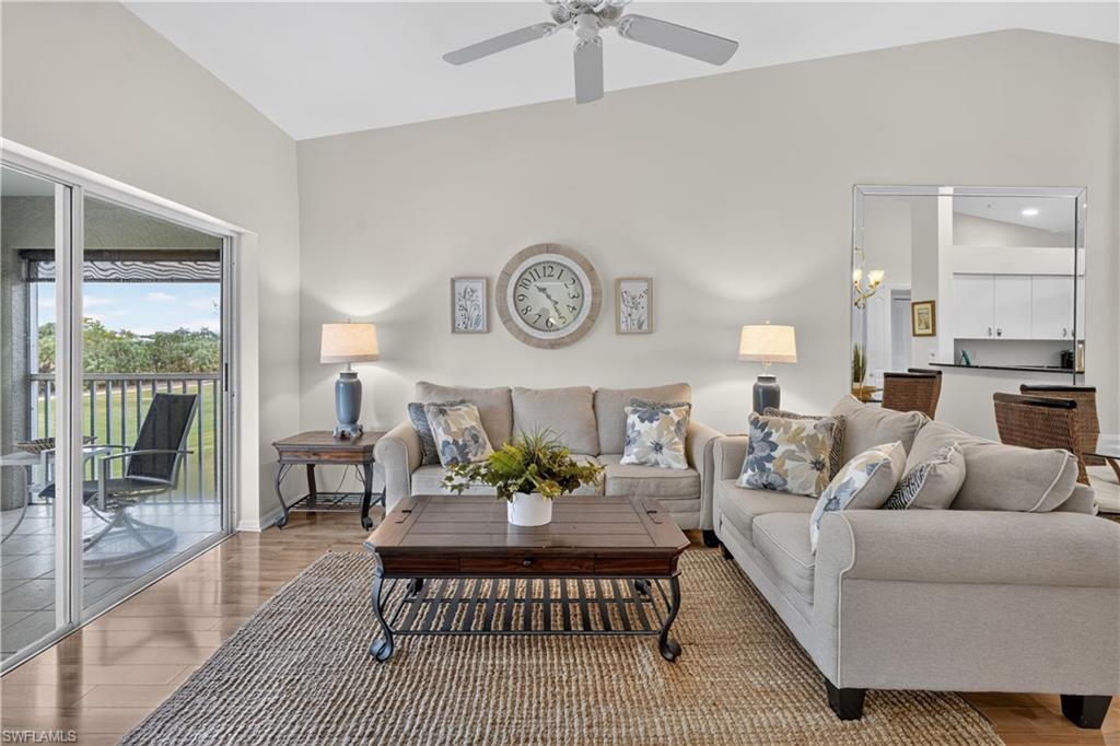 Vaulted ceiling and a ceiling fan, wood-finish flooring, and sliding glass doors to the outdoor patio