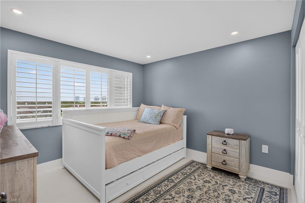 Spacious guest bedroom with Plantation Shutters and full size trundle bed.