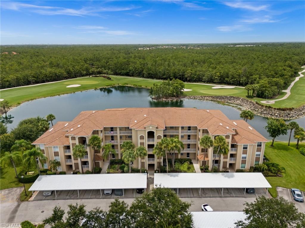Multi-story residential building with a tile roof, situated alongside a water feature and golf course greens