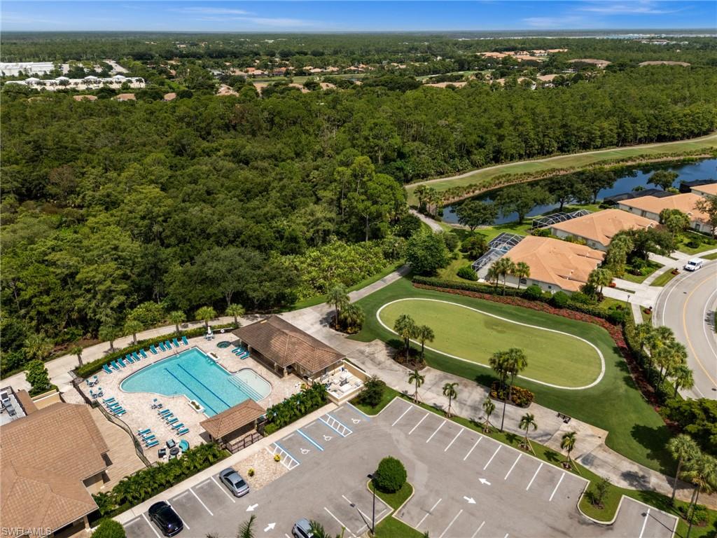 Resort-style pool area with ample lounge seating, adjacent clubhouse, and a dedicated putting green