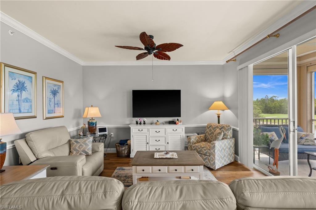Living space featuring wood-finish flooring, crown molding, and a ceiling fan