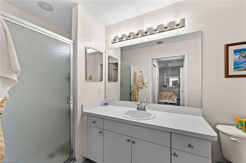 Bathroom featuring a white vanity with integrated sink, chrome-finish faucet, and a large wall-mounted mirror