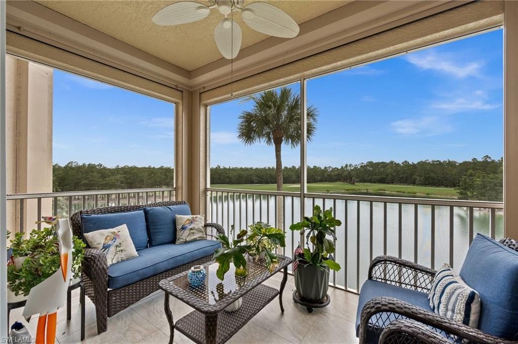 Screened balcony featuring a ceiling fan, tiled flooring, and a railing system