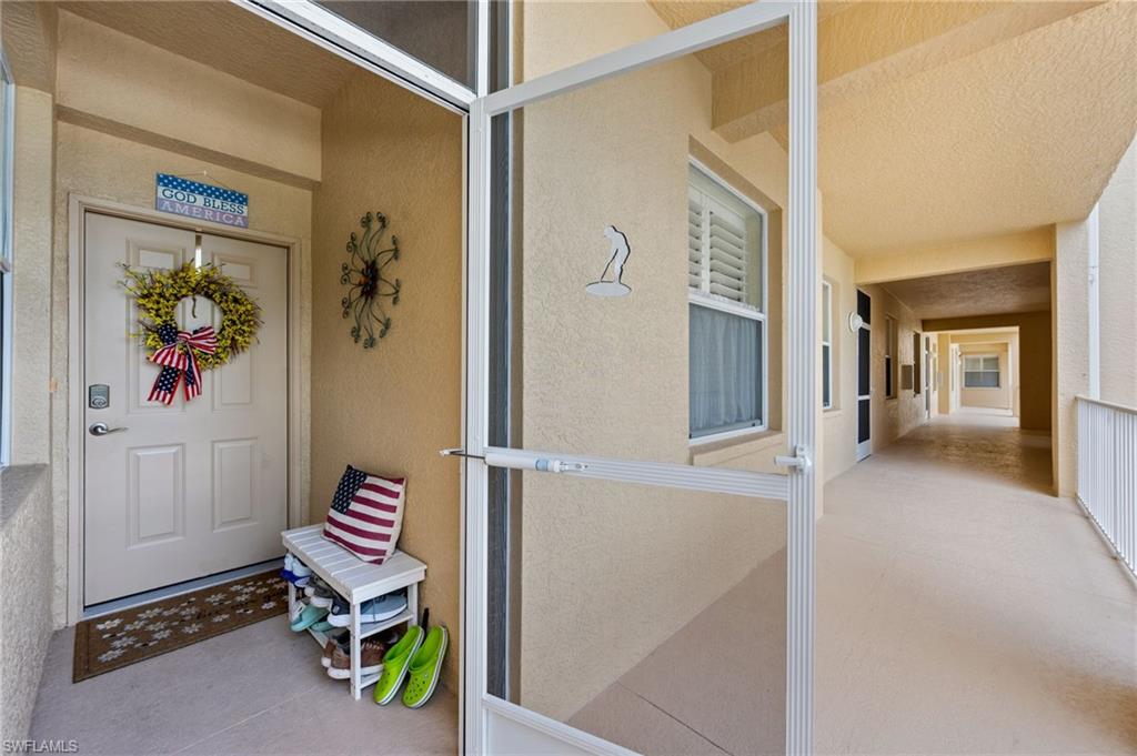 Entryway featuring a white paneled door with a modern handle set and an exterior window with plantation shutters