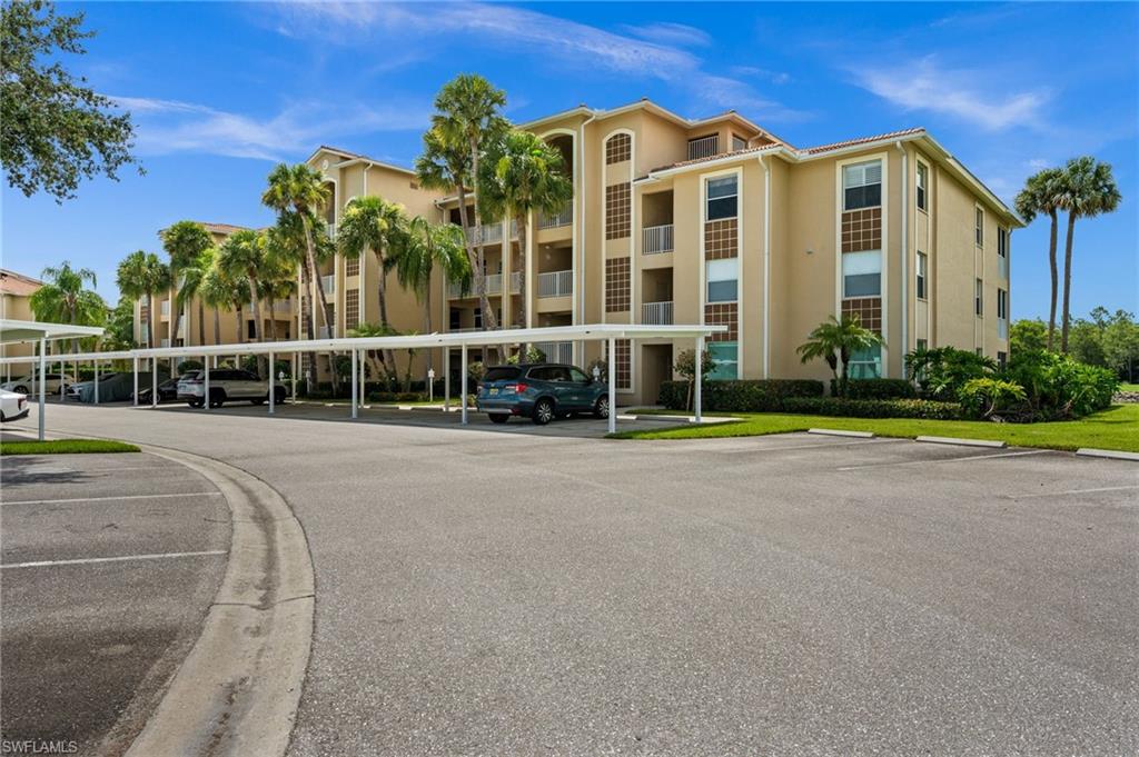 Multi-story residential building featuring a stucco exterior, tile roofing, and multiple private balconies