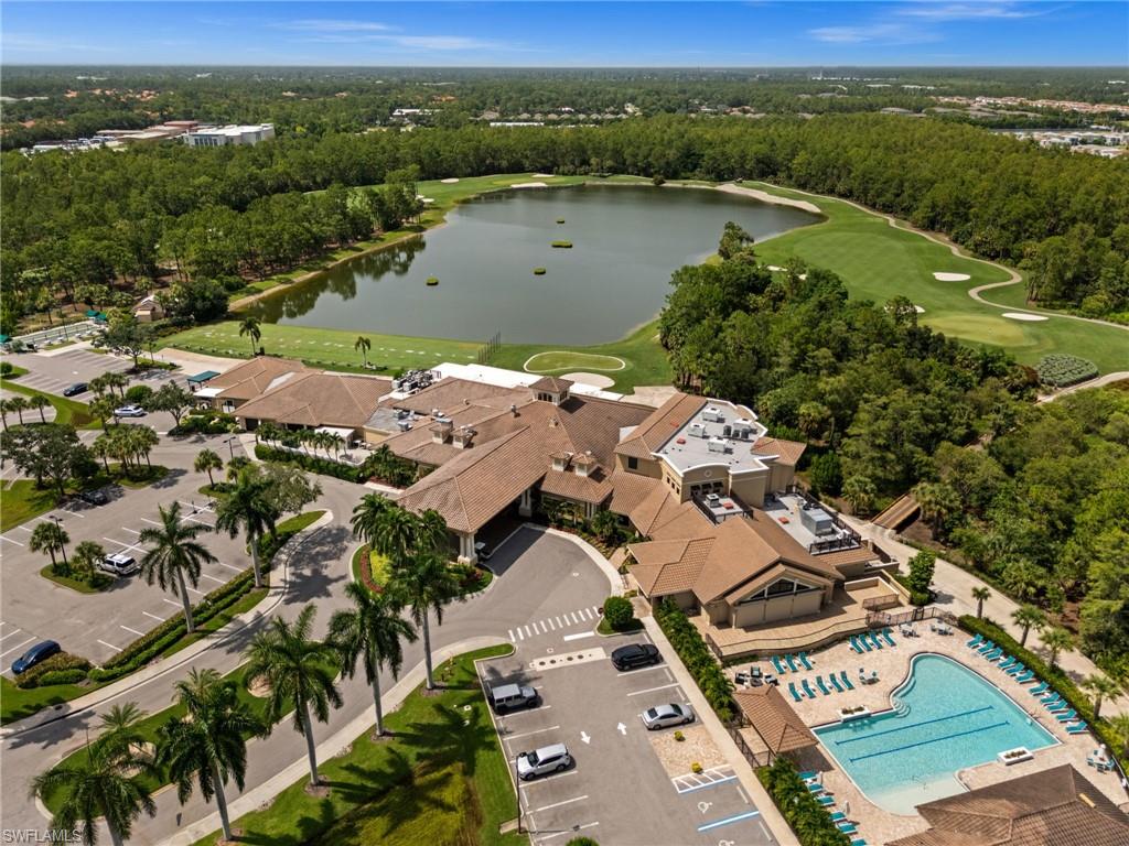 Expansive golf course and lake panorama featuring a multi-building clubhouse, swimming pool, and ample parking