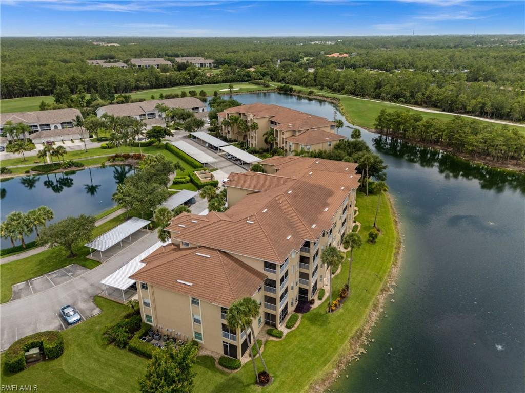Multi-story residential complex featuring tile roofing, balconies, and an exterior with a light-toned finish