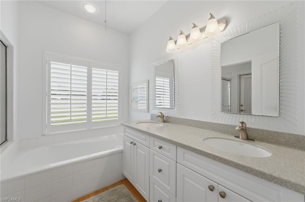The spa-inspired primary bath offers dual comfort-height vanities, custom mirrors, a tranquil soaking tub, and an elegant walk-in shower, creating a serene private retreat designed for relaxation and everyday luxury.