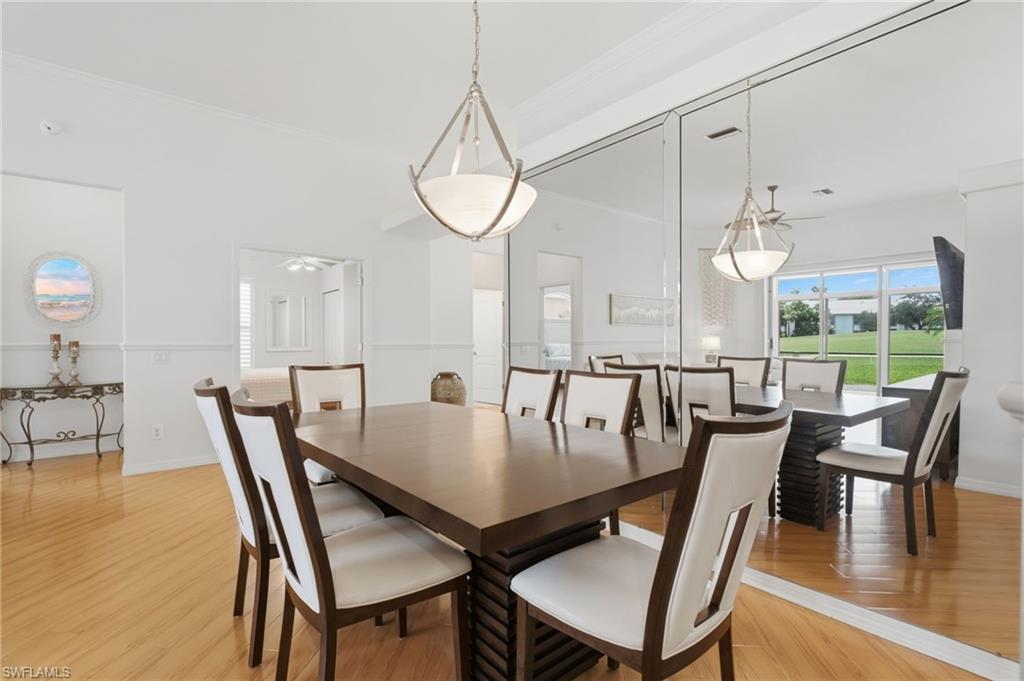 The formal dining room is enhanced by dramatic floor-to-ceiling mirrors that create a grand sense of space while beautifully reflecting the lush golf course views, adding depth, light, and timeless elegance.