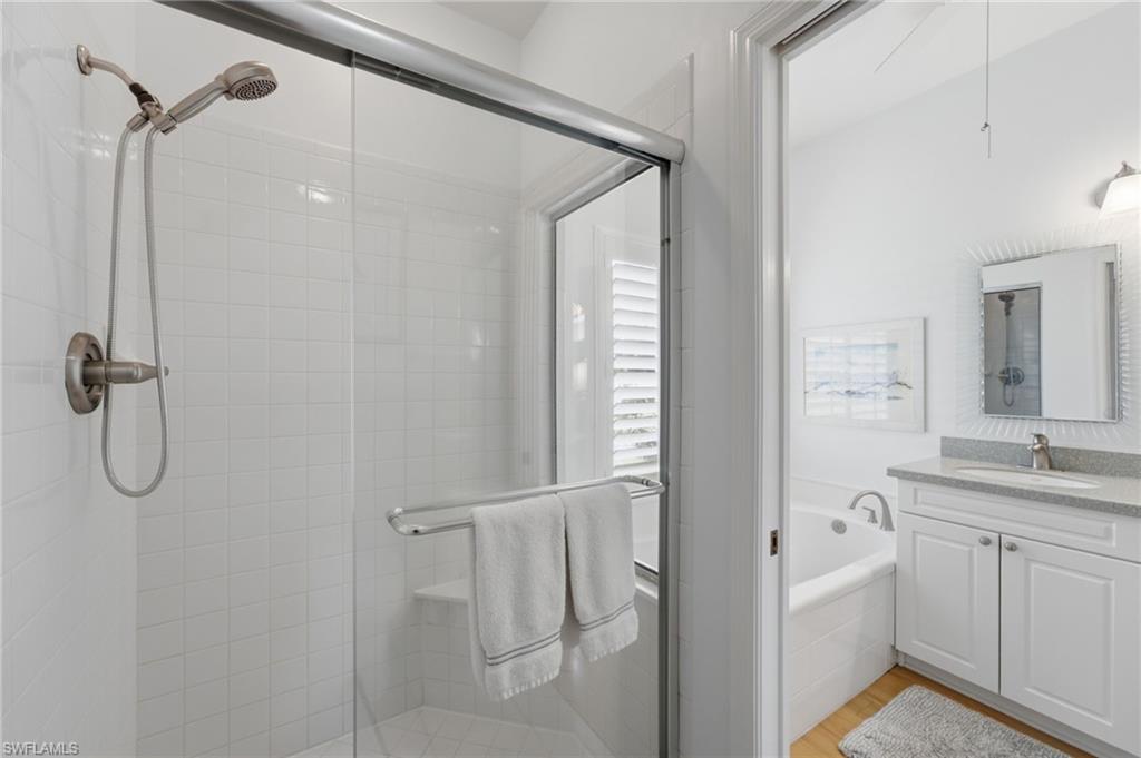 The serene primary suite offers private lanai access and a beautifully appointed ensuite bath featuring a newly updated walk-in shower with a new showerhead, creating a luxurious retreat designed for comfort and relaxation.