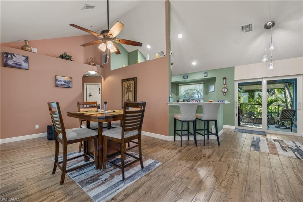 Open-concept interior featuring wood-finish flooring, vaulted ceilings, and a ceiling fan