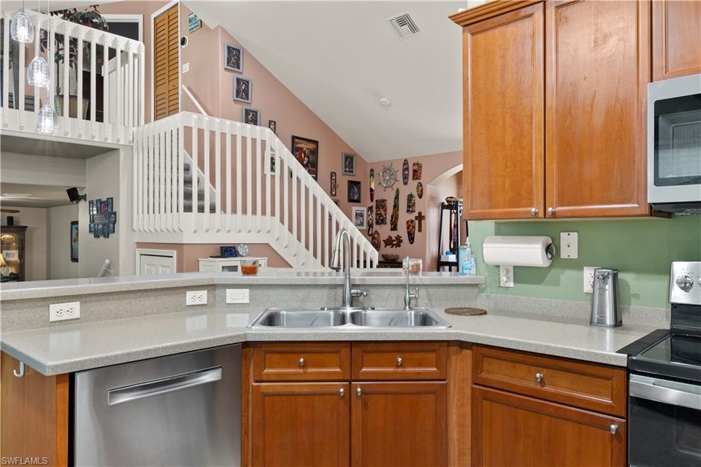 Kitchen featuring a stainless steel double basin sink, light-toned countertops, and wood cabinetry