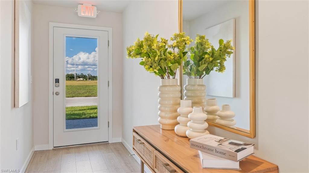 Model home. Entryway with hardwood / wood-style flooring and baseboards