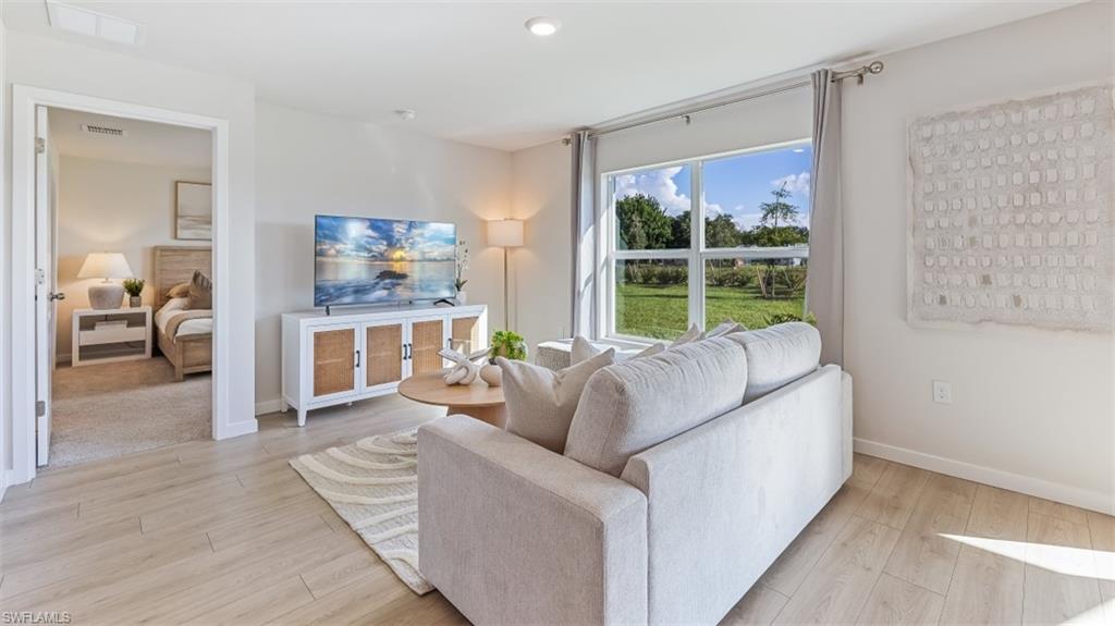 Model home. Living area featuring light wood-style flooring and baseboards