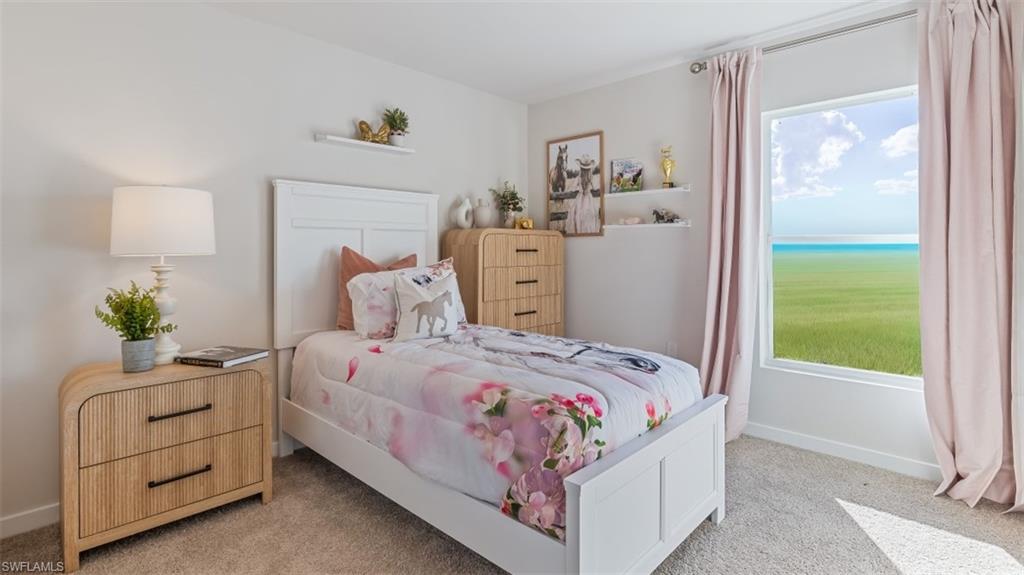 Model home. Bedroom featuring light colored carpet and a water view