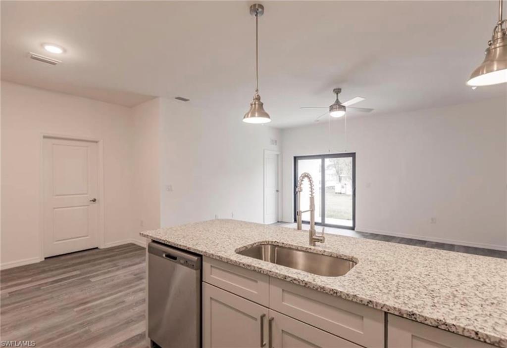Kitchen island featuring a stainless steel undermount sink and gooseneck faucet