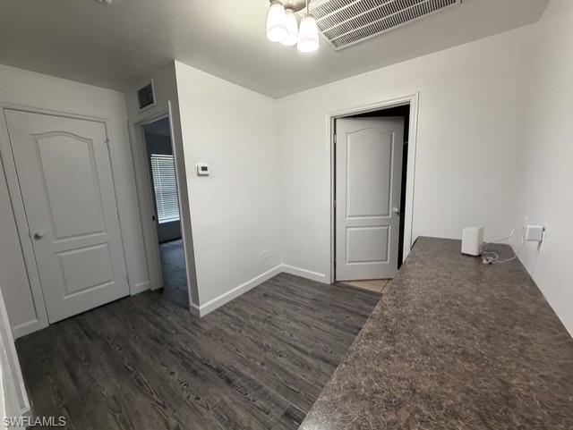 Interior space featuring wood-finish flooring, white painted walls, and a textured countertop
