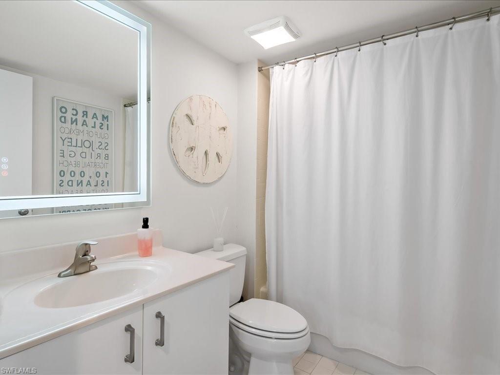 Bathroom featuring a single vanity with a laminate countertop, undermount sink, and brushed nickel faucet