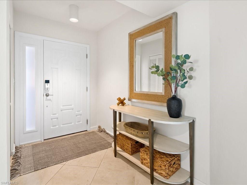 Entryway featuring a paneled door with sidelite, a contemporary ceiling light fixture, and tile flooring