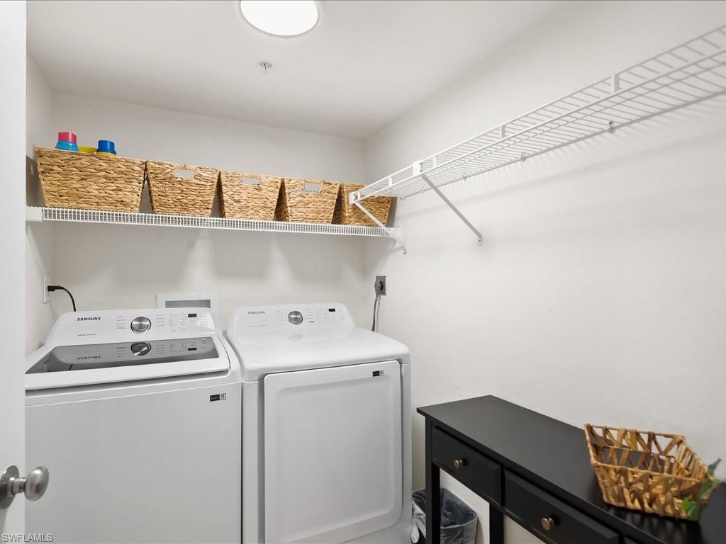 Dedicated laundry area featuring a white top-load washing machine and front-load dryer