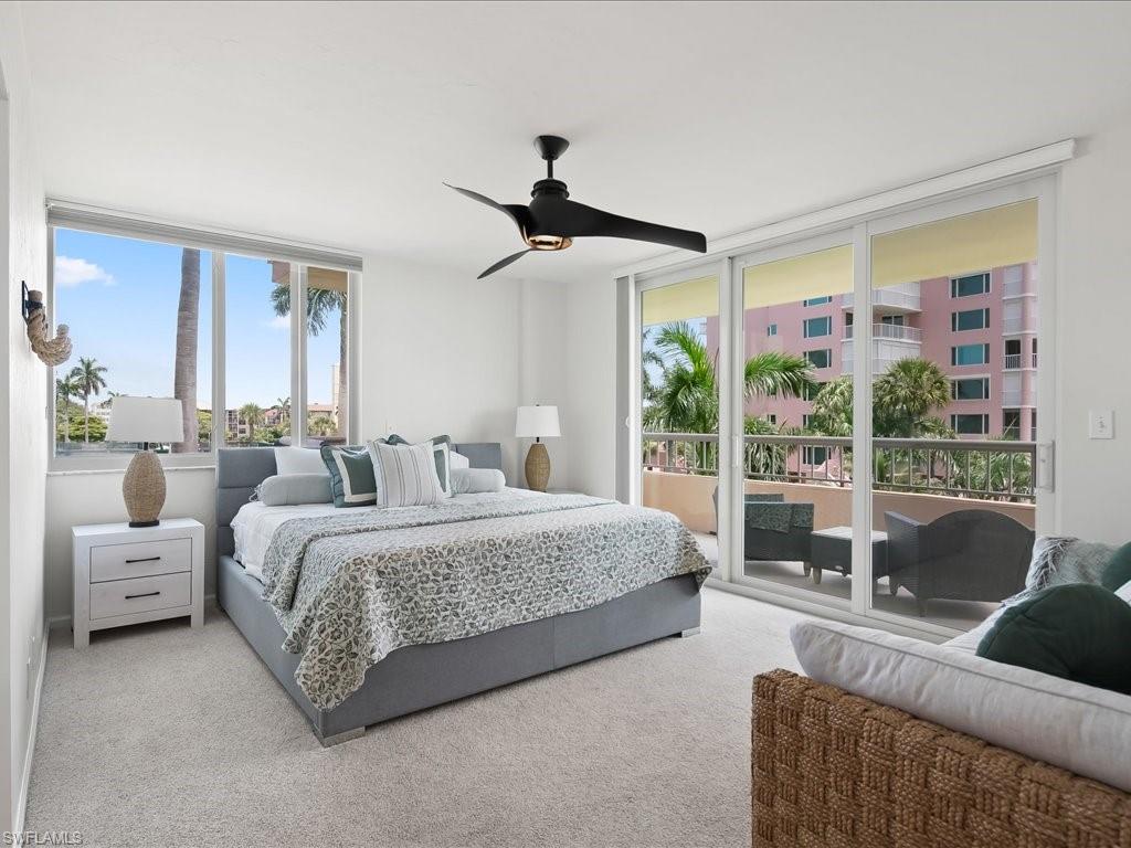 Carpeted interior space featuring a large window and sliding glass door to an exterior balcony