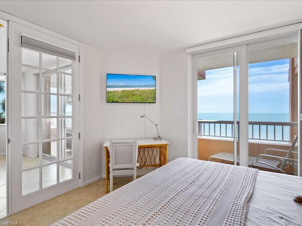 Sliding glass doors opening to a private balcony with water scenery
