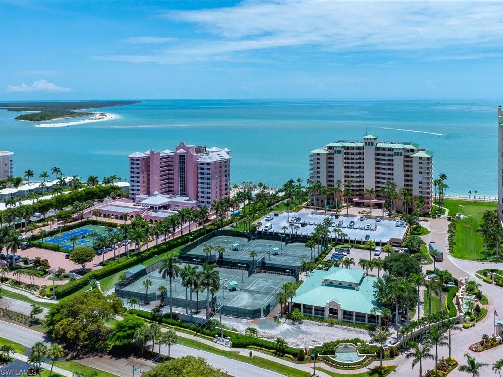 Expansive coastal property featuring multiple high-rise buildings, extensive tennis courts, and landscaped grounds
