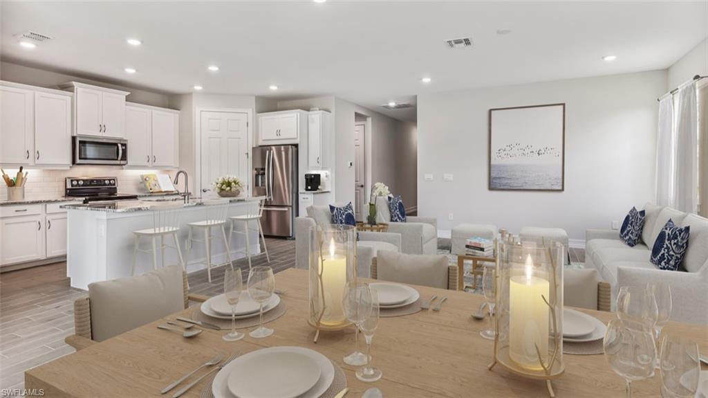 Open-concept living space featuring a dining area, kitchen, and gathering room