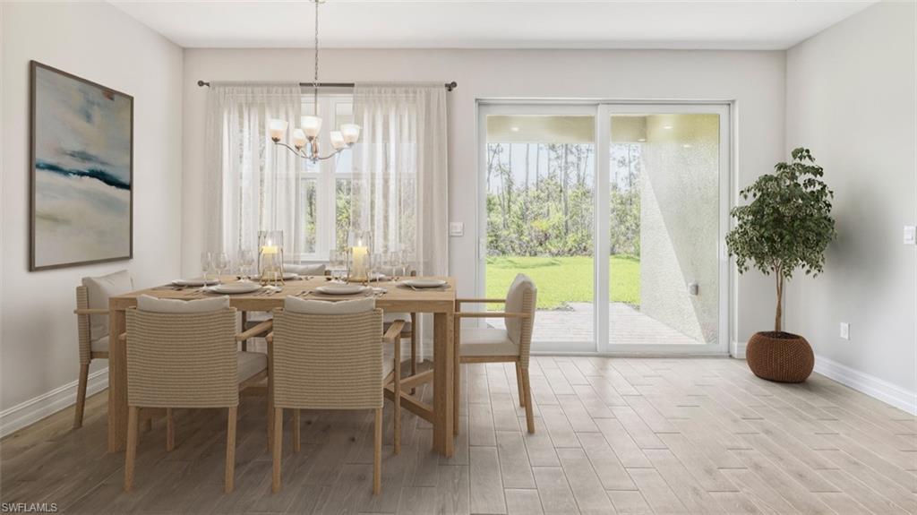 Open-concept dining area featuring light-tone wood-finish flooring, a modern chandelier, and direct access to an outdoor patio through sliding glass doors