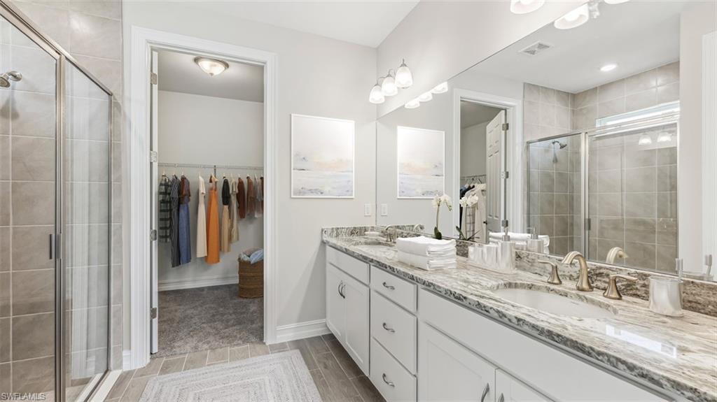 Dual vanity with white cabinetry and patterned stone countertop