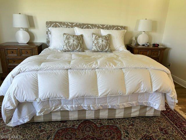 Bedroom with wood finished floors and baseboards