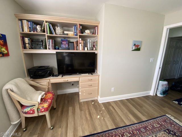 Office space featuring built in study area and wood finished floors
