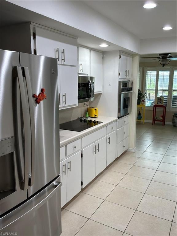 Kitchen featuring white cabinetry, stainless steel appliances, a built-in oven, and a ceramic tile floor