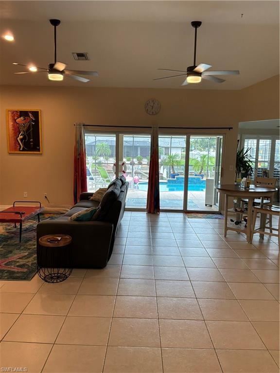Spacious interior with neutral tile flooring throughout, featuring a vaulted ceiling with two ceiling fans