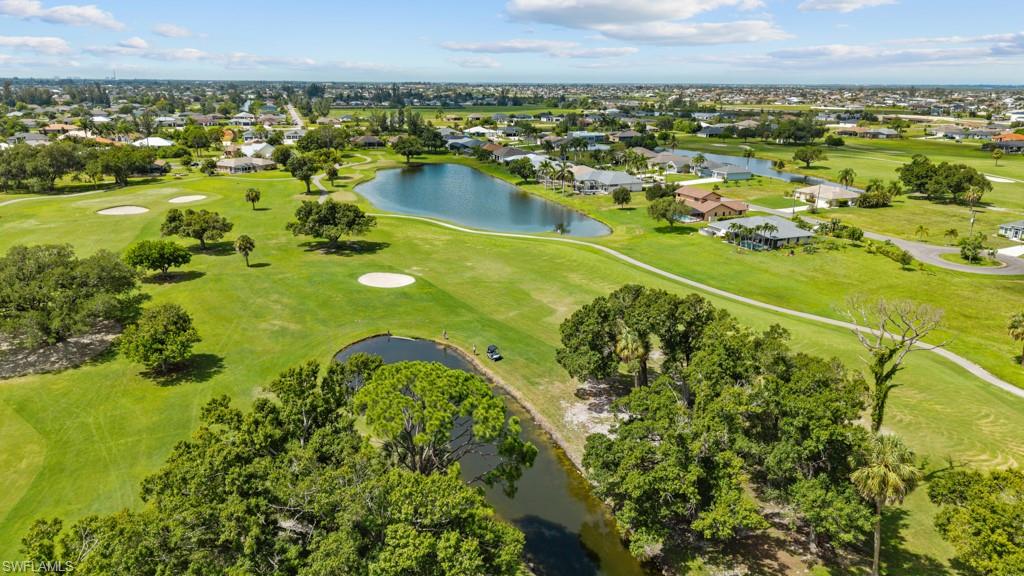 Expansive golf course setting featuring multiple greens, sand traps, and water features