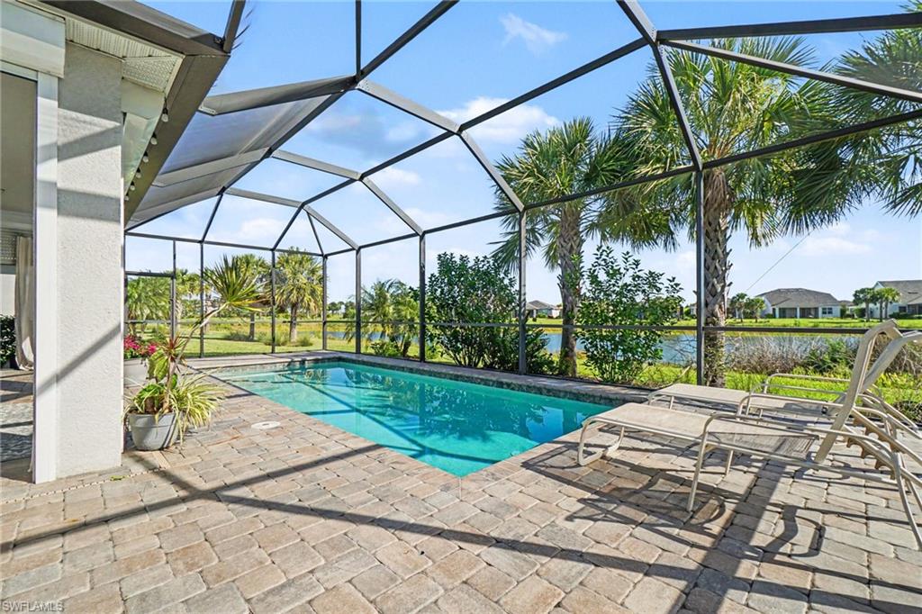 Screened enclosure featuring a rectangular pool, paver patio, and water frontage