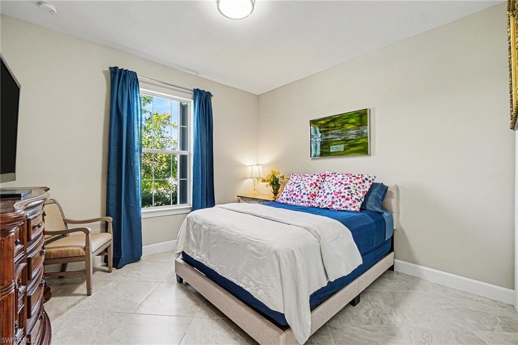 Bright room featuring a large window, tiled flooring, and neutral wall tones