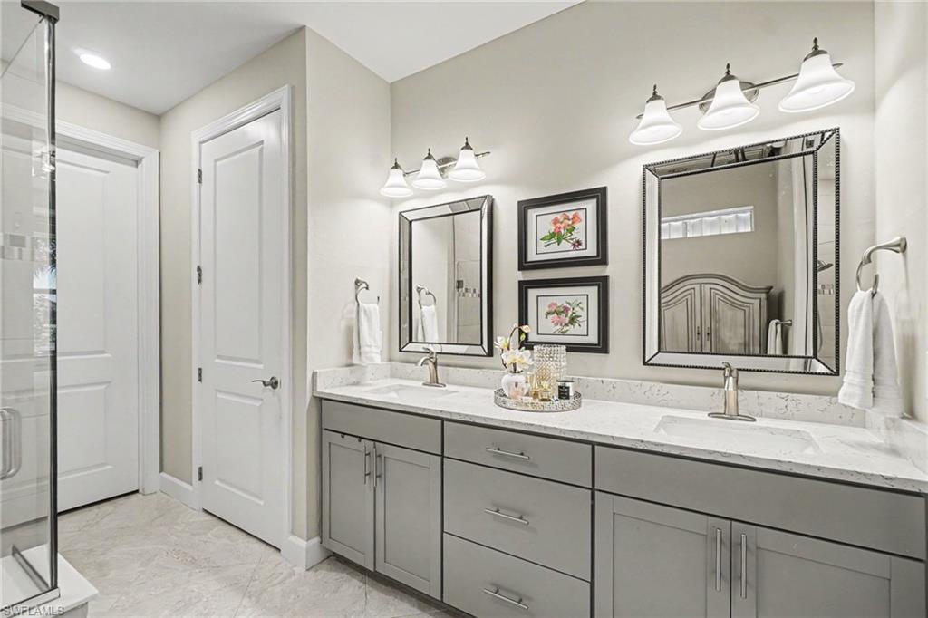 Double vanity with gray cabinetry, white countertops, and undermount sinks