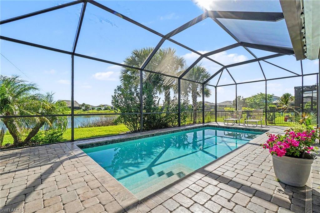 Screened lanai featuring a swimming pool, paver deck, and water frontage