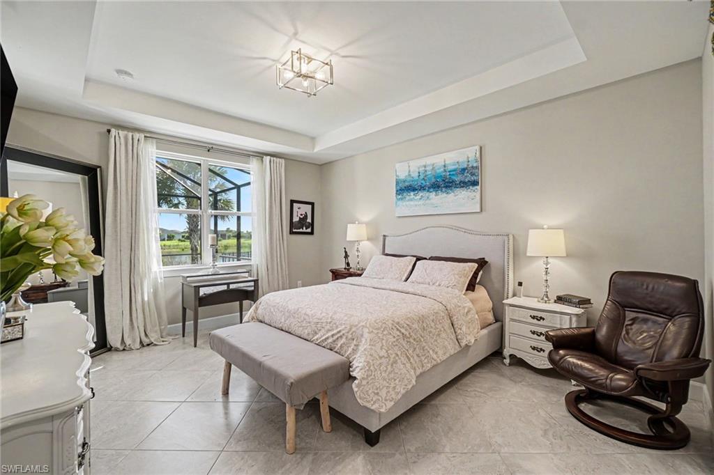 Tray ceiling with recessed lighting and a central geometric light fixture