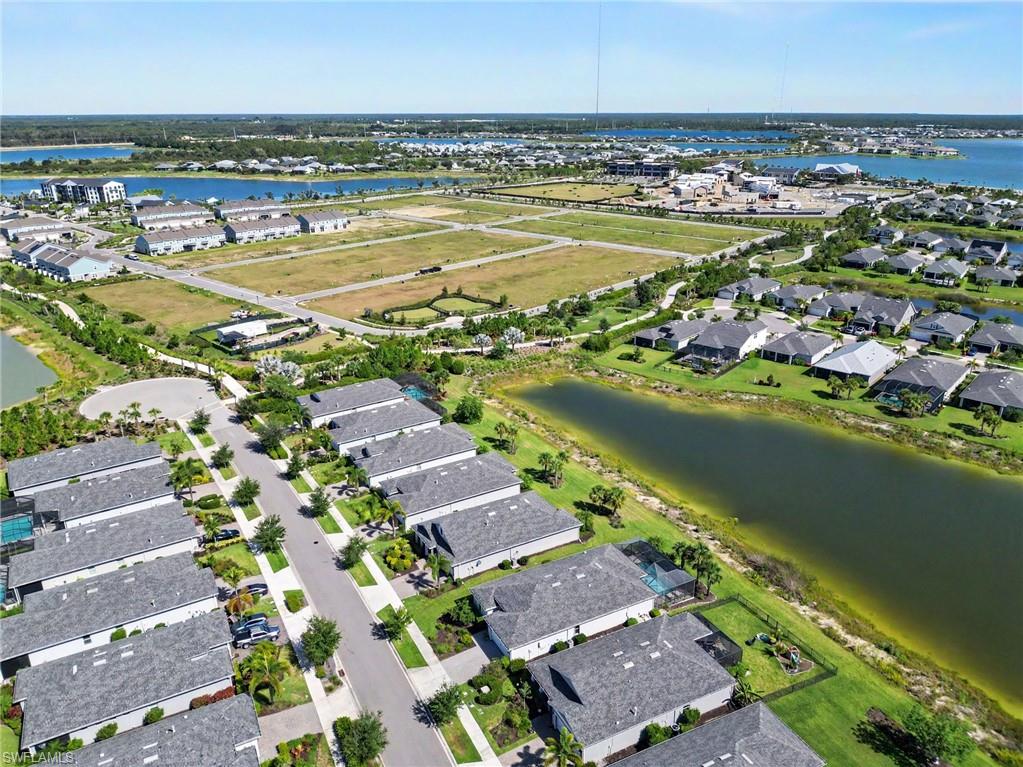 Residential development featuring a mix of single-family homes and multi-unit buildings, multiple water features, and significant undeveloped land parcels