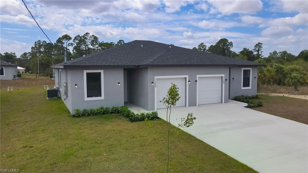 Contemporary duplex featuring a stucco exterior, dark shingle roof, two white garage doors, and a concrete driveway
