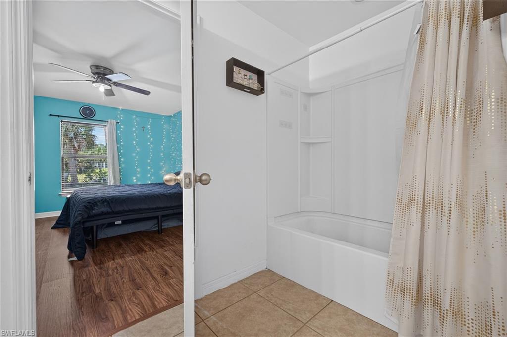 Bathroom featuring a white tub-shower combination with integrated shelving